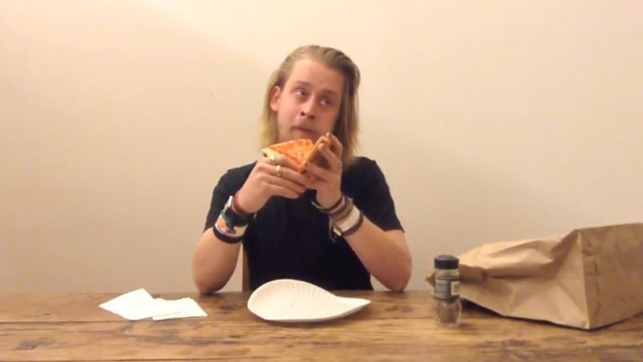 Macaulay Culkin Eating a Slice of Pizza